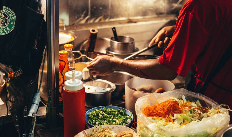 A cook working at a street food stall
