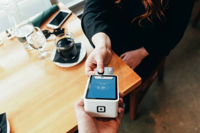 Someone paying contactless with a bank card