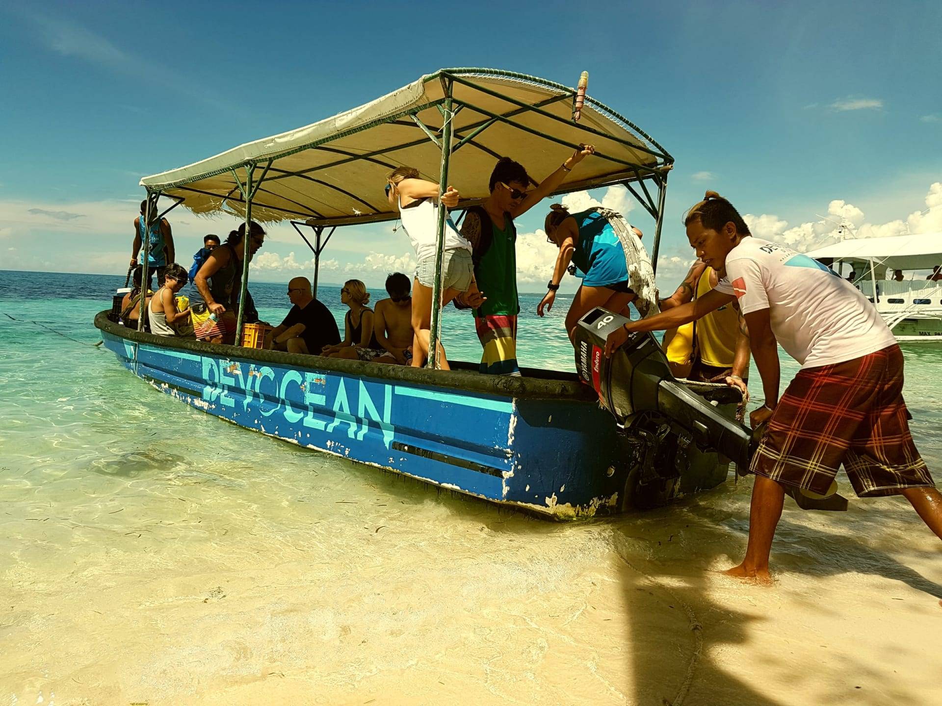 The Devocean Divers boat being pushed ashore in shallow water