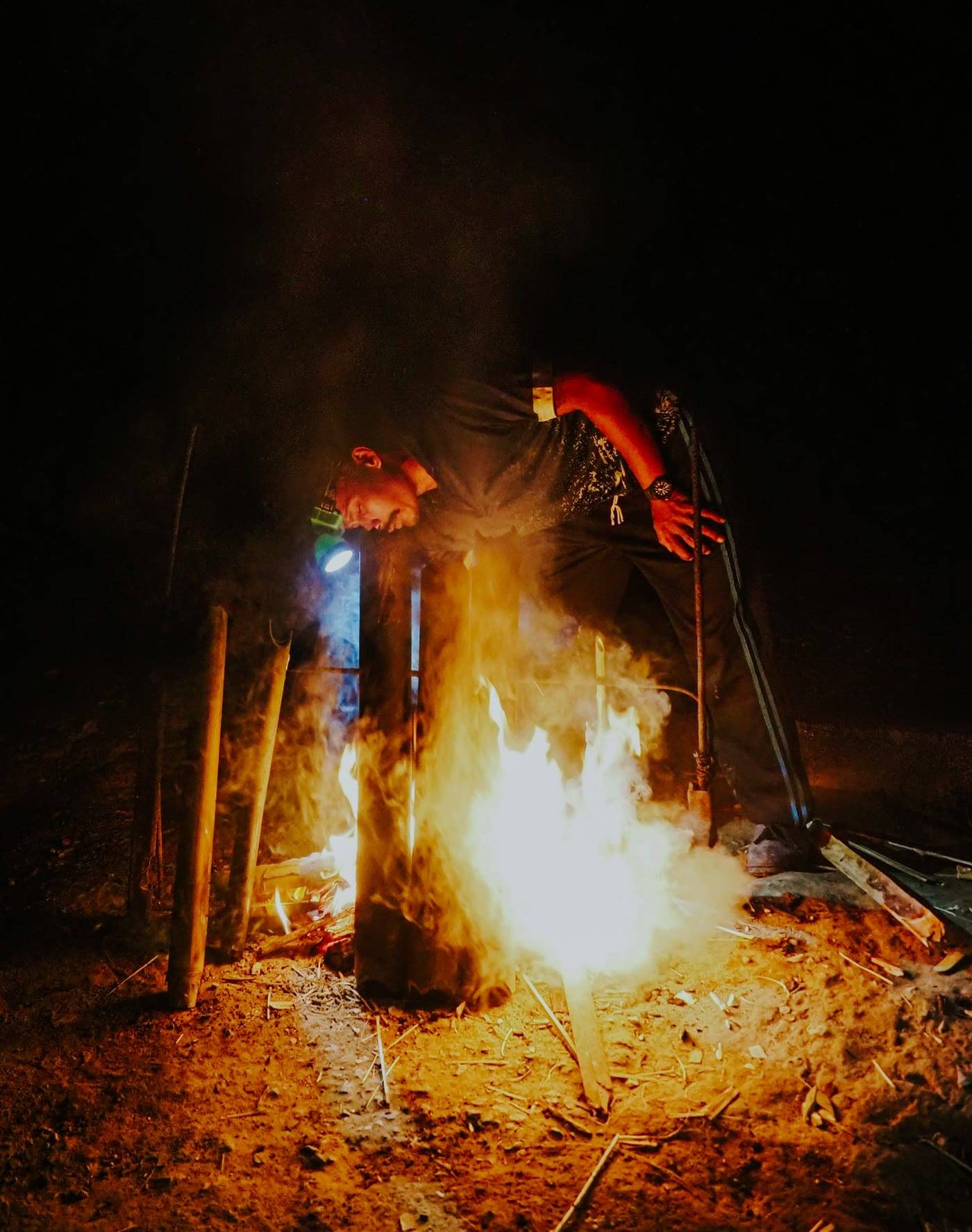 Camp fire in the dark with bamboo above the flames