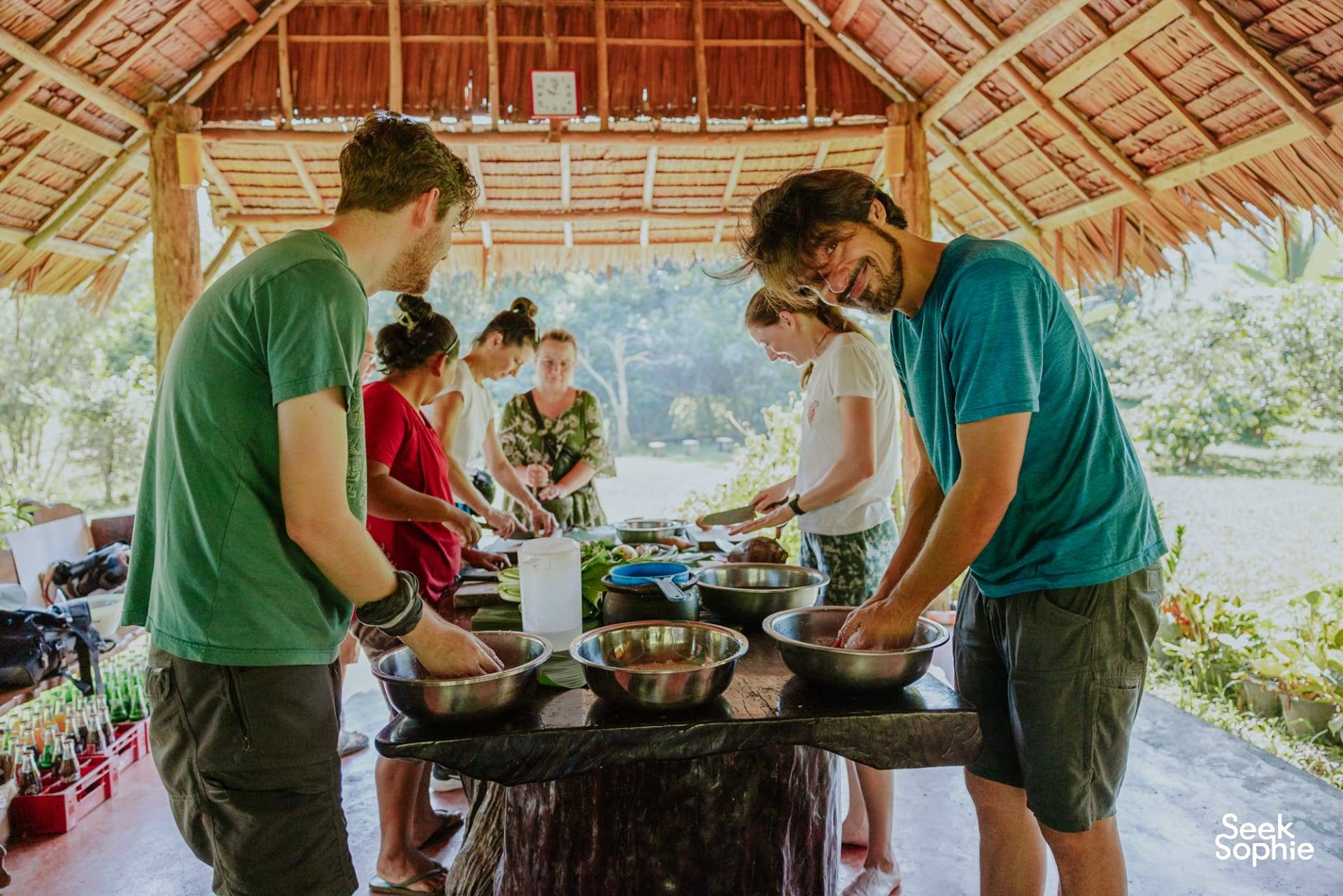 Travellers cooking together under the thatched roof at Rungfah Farm Stay in Khao Sok