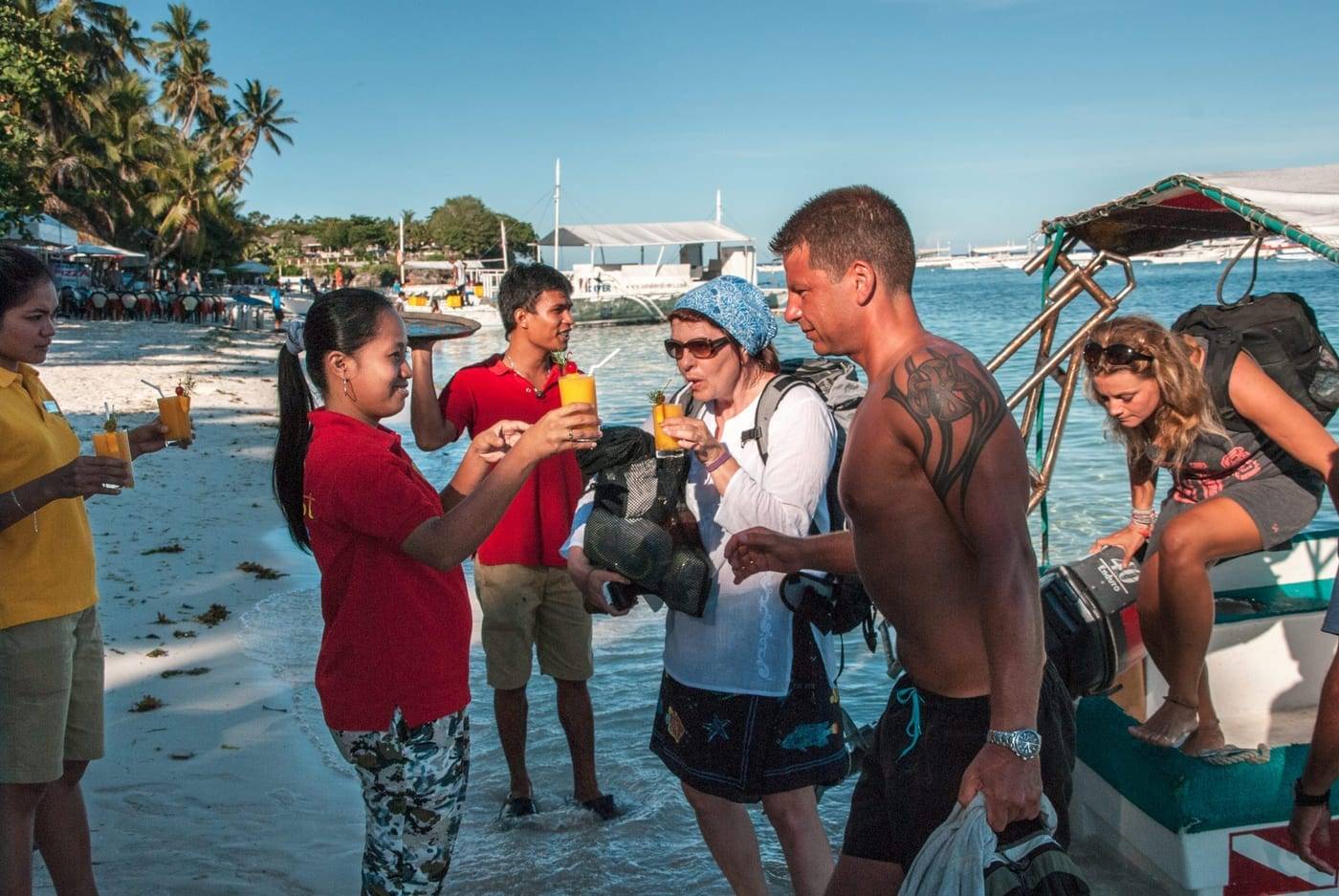 The Seaquest team welcoming divers with a drink on the beach