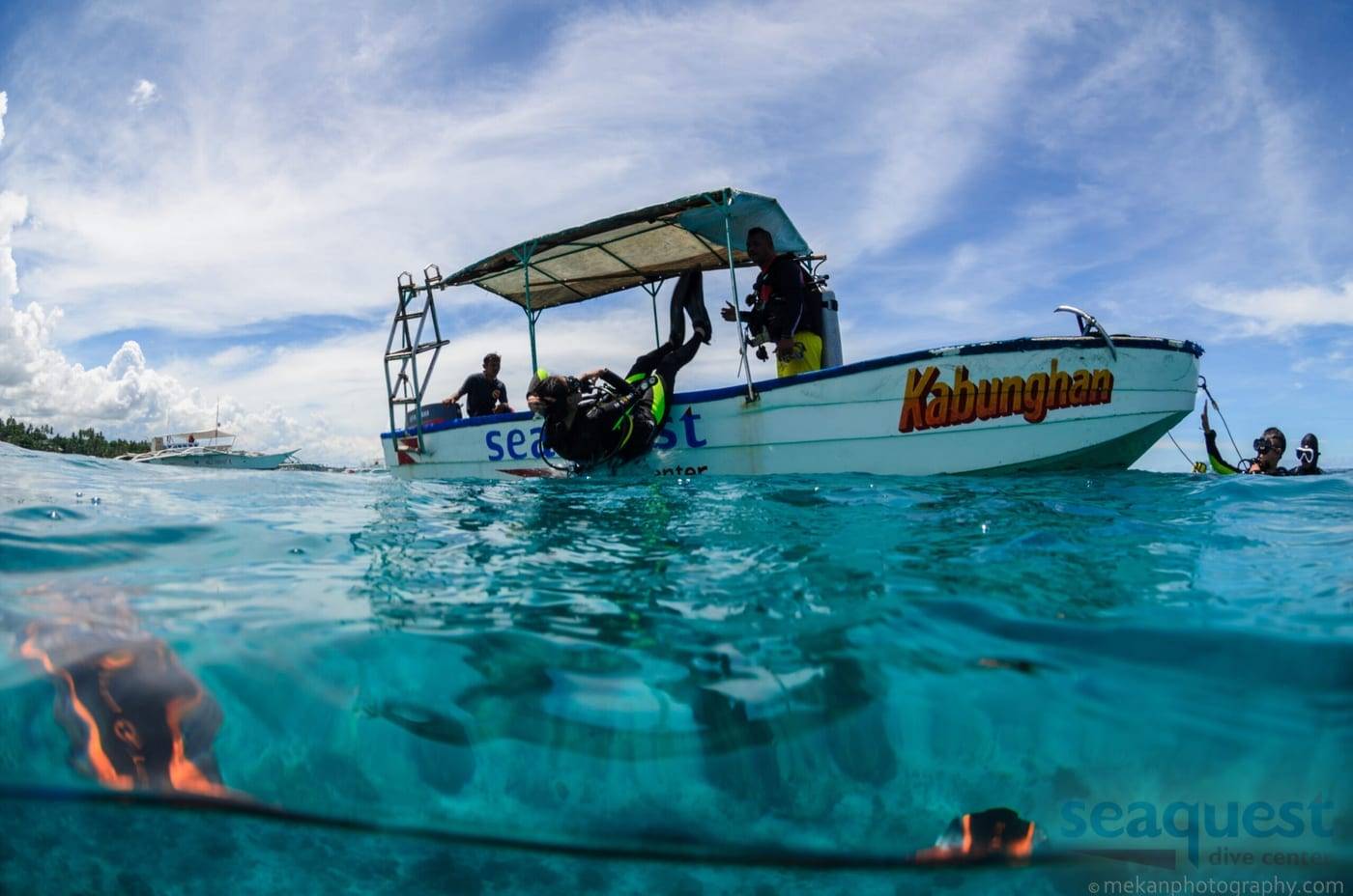 Divers entering the water from the Seaquest Dive Center boat