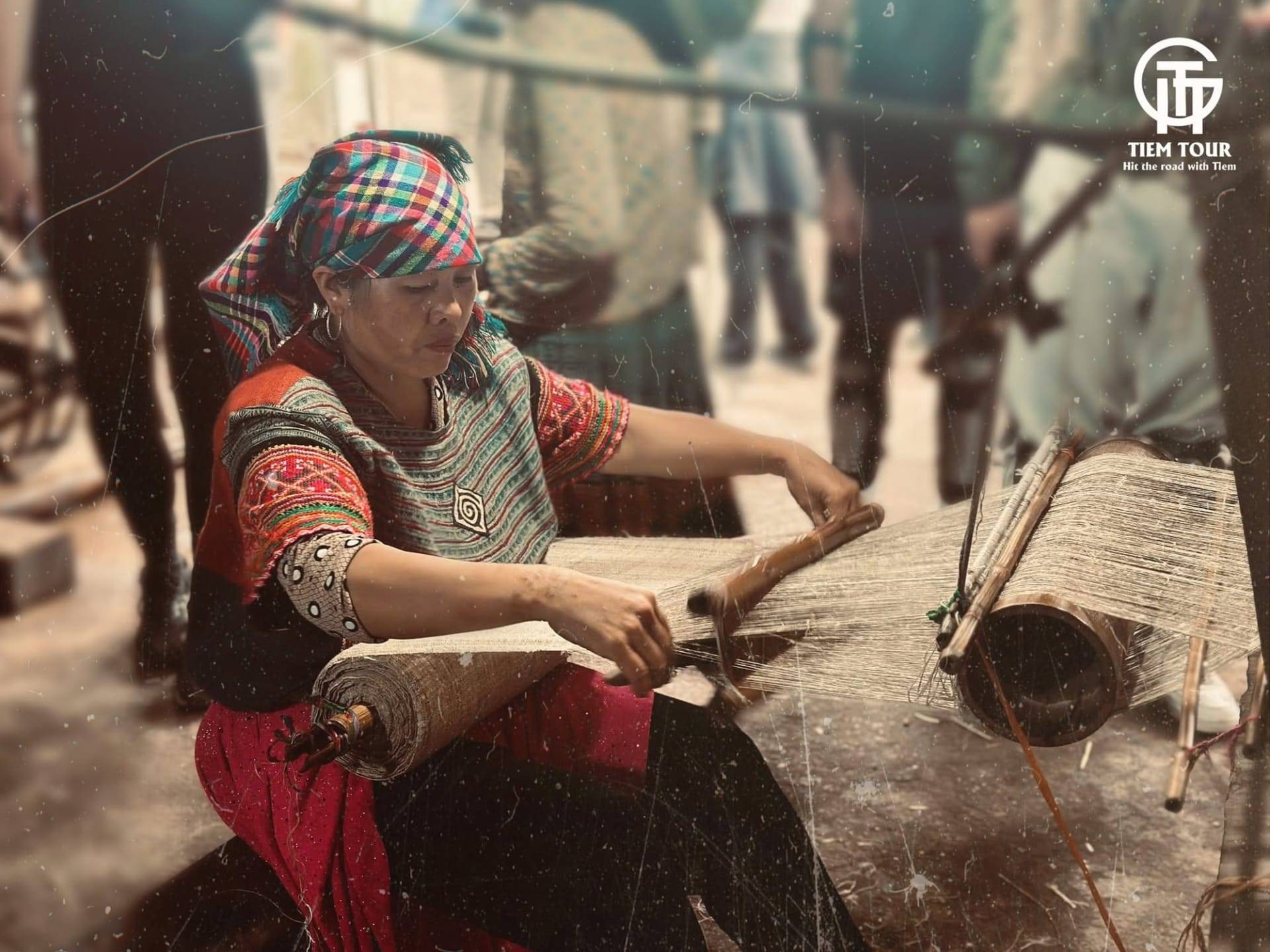 Woman weaving at a wooden loom in a village along the route