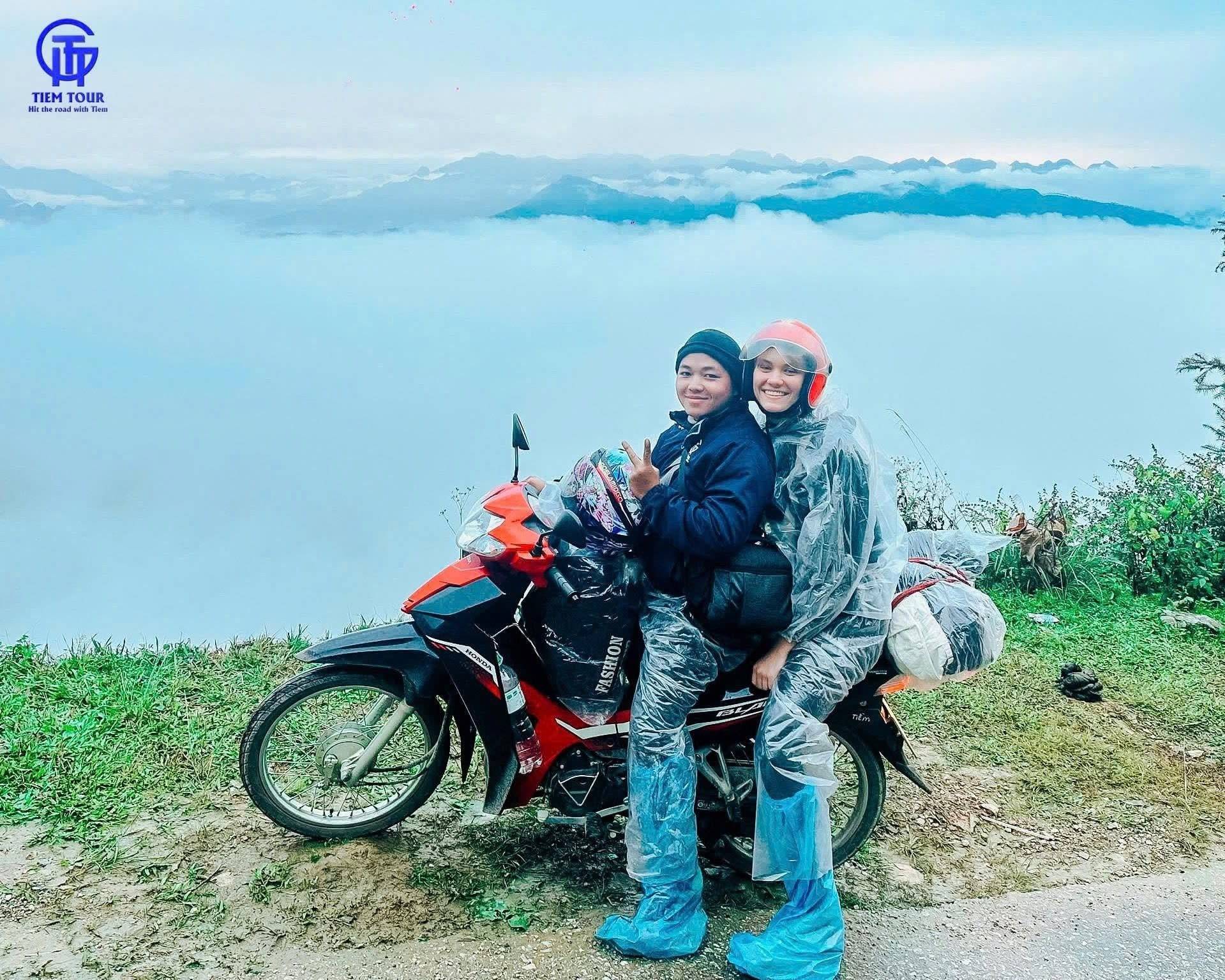 On the back of a bike at a viewpoint above a sea of cloud on the Ha Giang Loop