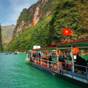 Boat with a Vietnamese flag on the emerald river at the bottom of the gorge