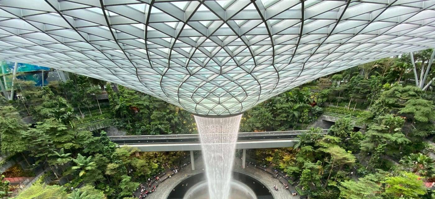 The Rain Vortex in Jewel Changi Airport surrounded by greenery