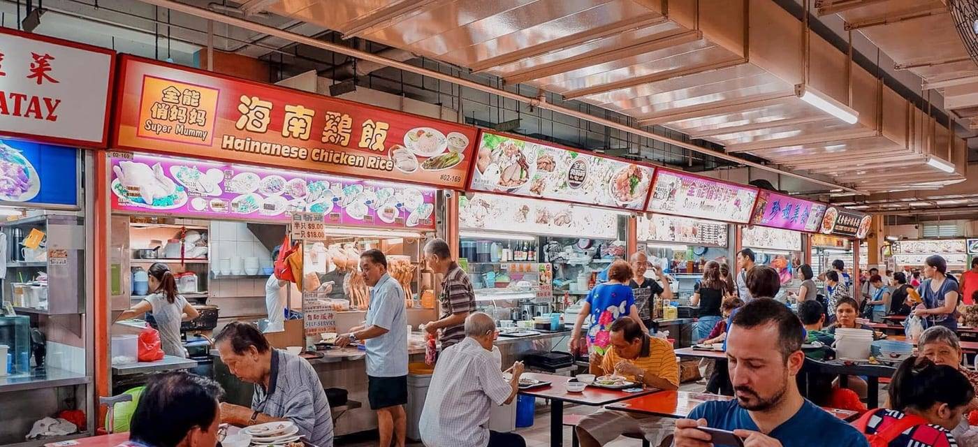 A busy hawker centre with a Hainanese chicken rice stall