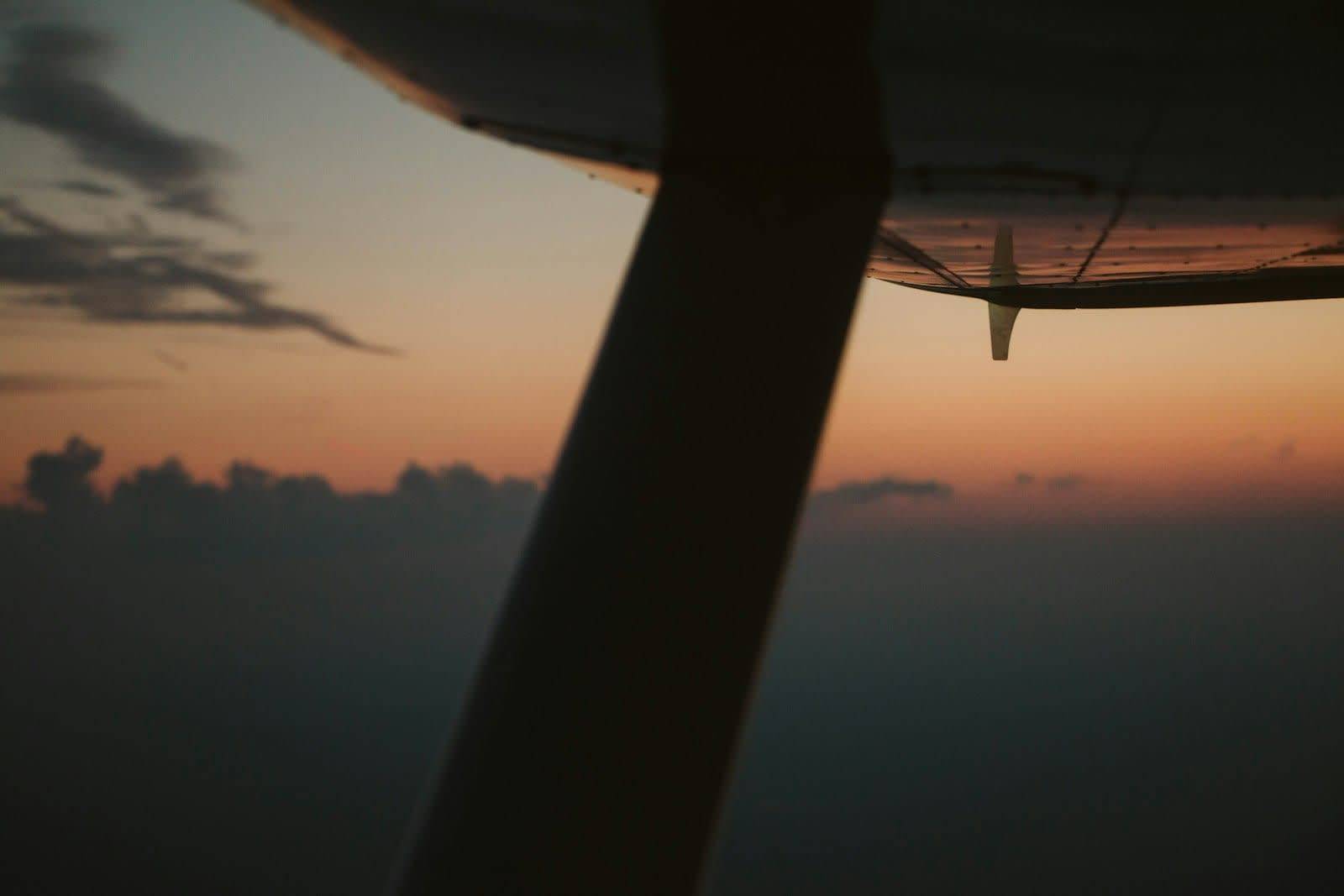 Aircraft wing above the clouds at sunset