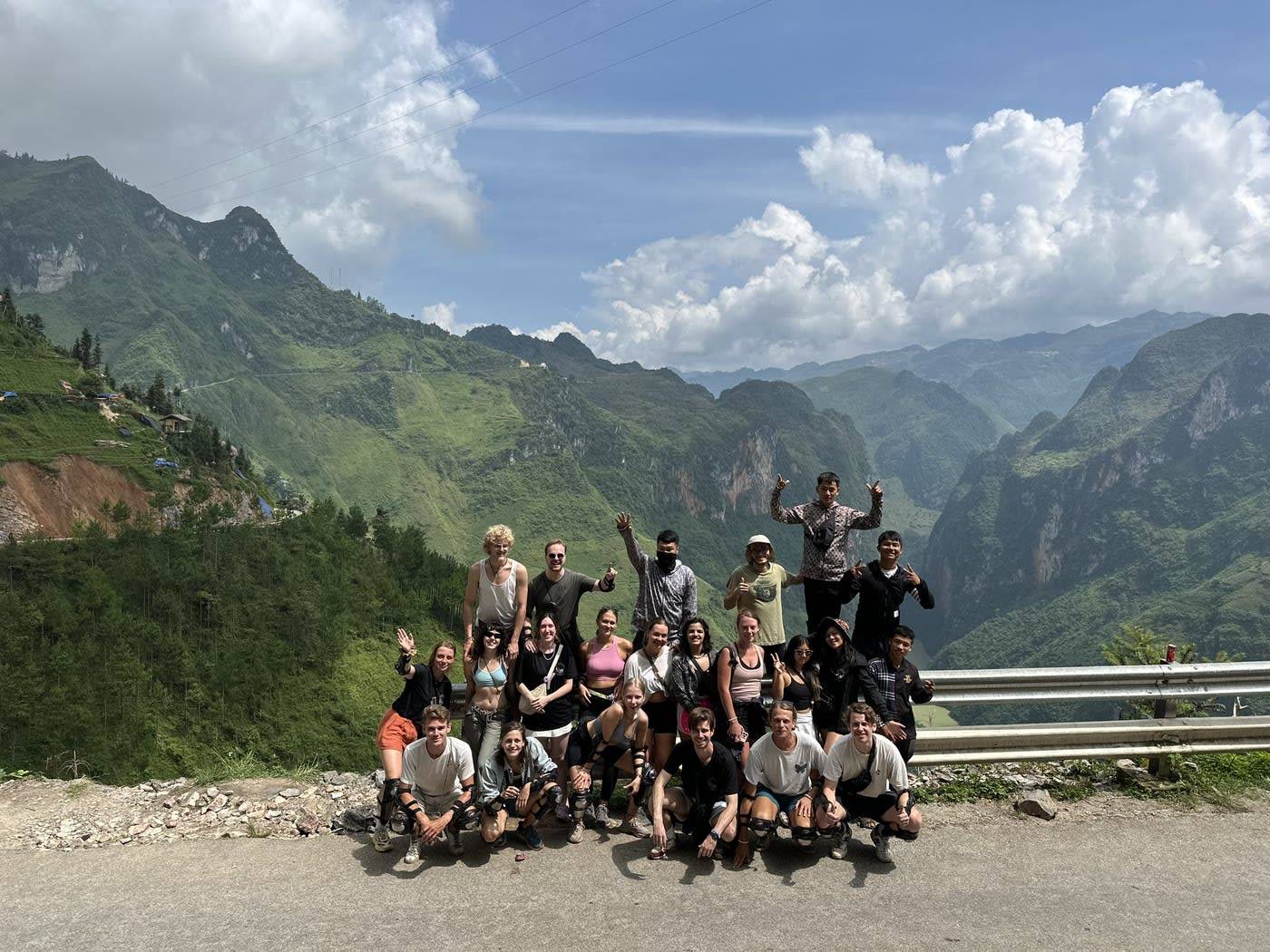 The Mama's Homestay group with their flag at a viewpoint