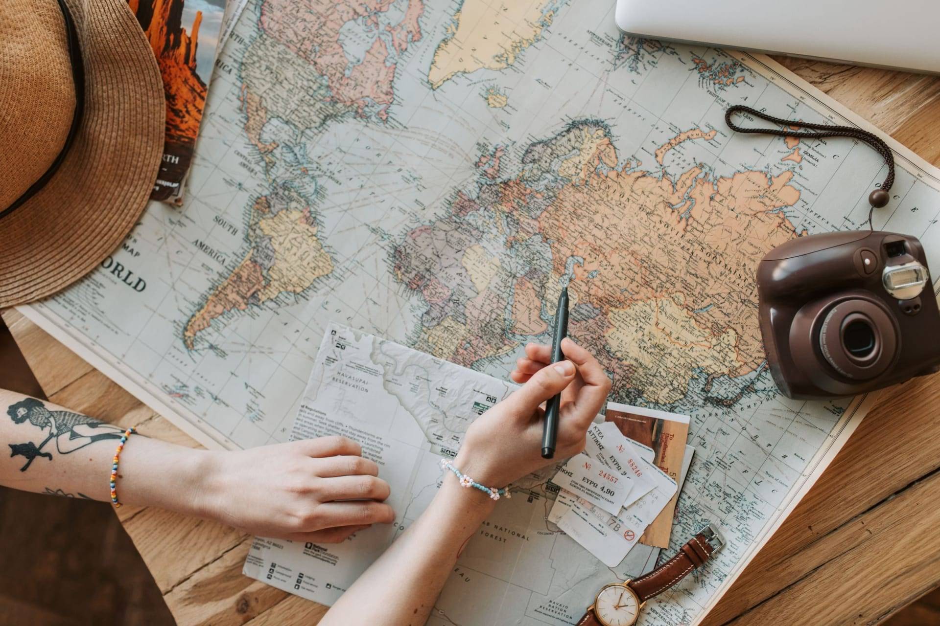 Traveller marking out a route on a world map with a pen