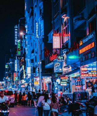 Busy street full of people and neon signs in District 1