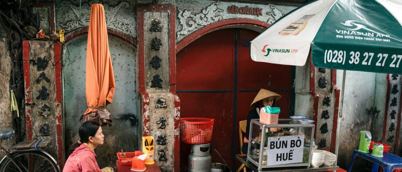 Woman waiting for a bowl of bun bo hue at a street stall in District 4