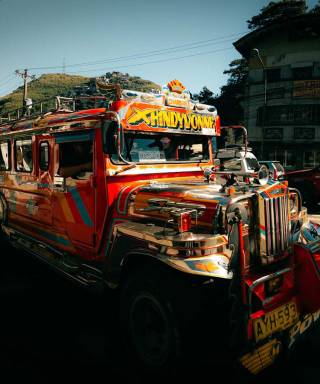 A brightly painted jeepney driving through a town