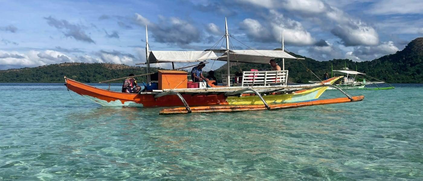 A traditional Filipino bangka boat on clear turquoise water